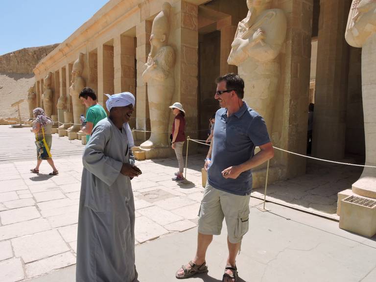 Lokale Egyptenaar lacht met toerist tijdens het foto's maken bij Hatsjepsut in Luxor